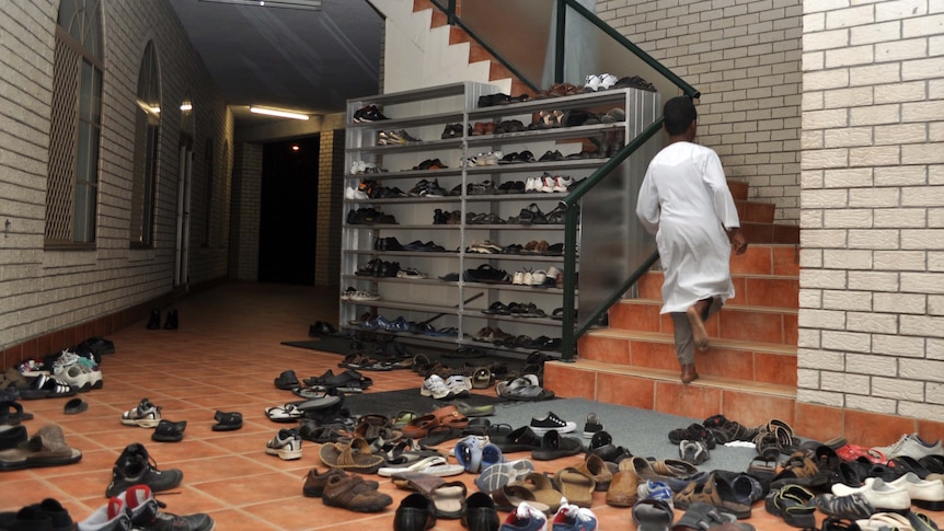 Shoes are shed as a boy runs upstairs to evening prayers at Darra Mosque on August 5, 2011.