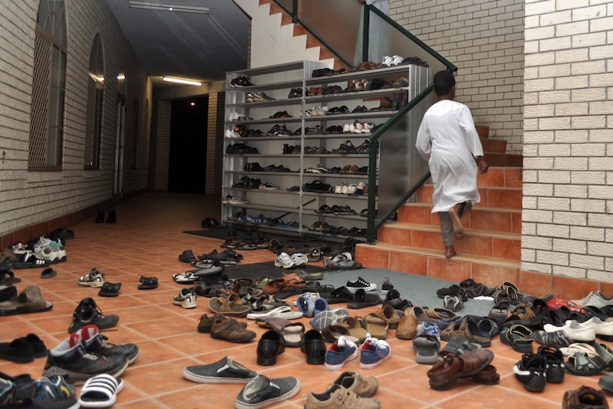 Shoes are shed as a boy runs upstairs to evening prayers at Darra Mosque on August 5, 2011.
