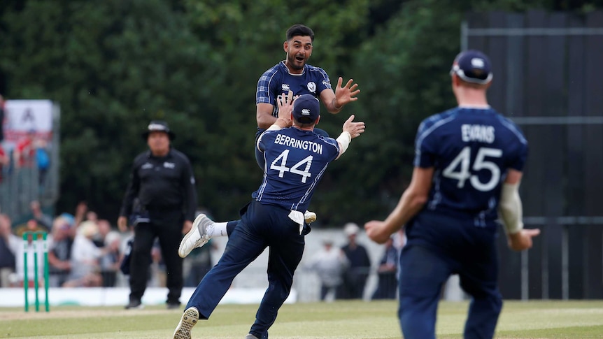 Scotland's Safyaan Sharif jumps into the air after his team wins the match.