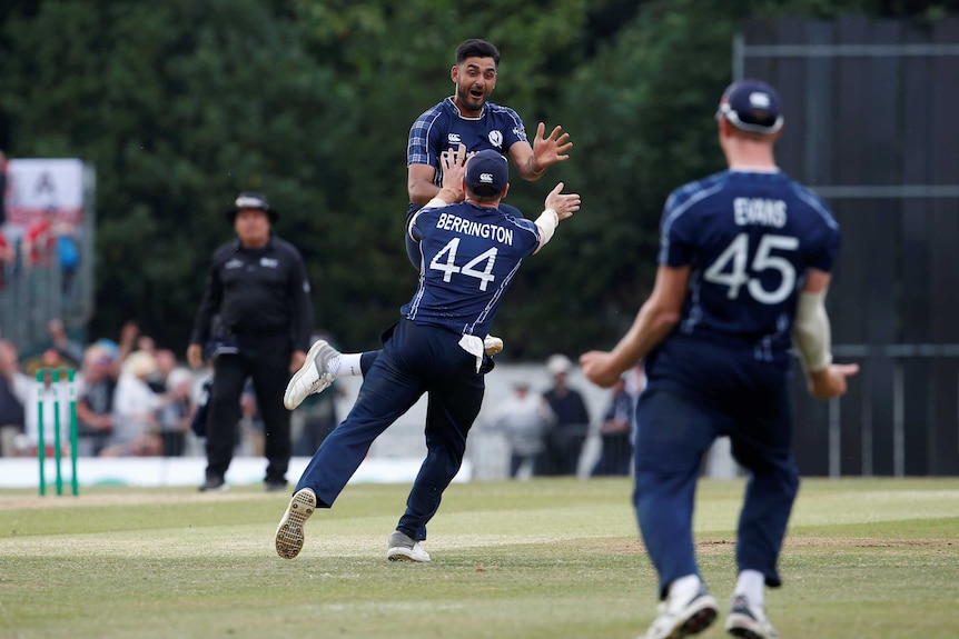 Scotland's Safyaan Sharif jumps into the air after his team wins the match.