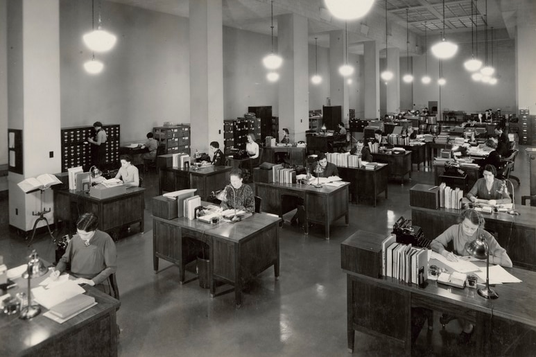 A 1937 photograph shows US National Archives workers at their desks.
