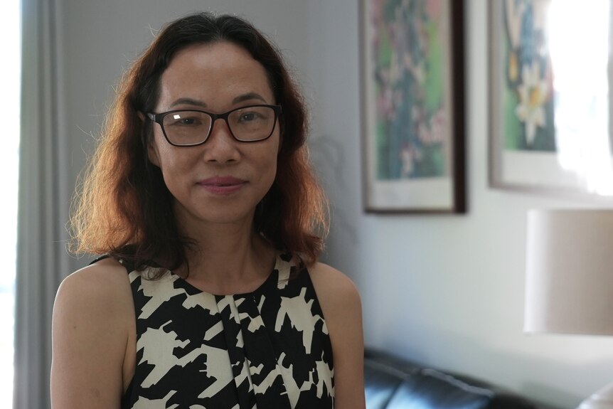 Dr Wendy Li wears glasses and has wavy hair.