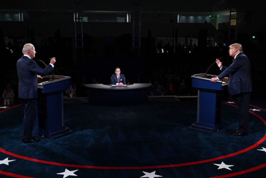 Joe Biden and President Donald Trump stand behind their own individual podiums while in a heated debate on stage.