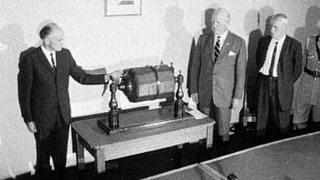 Men stand beside ballot barrel