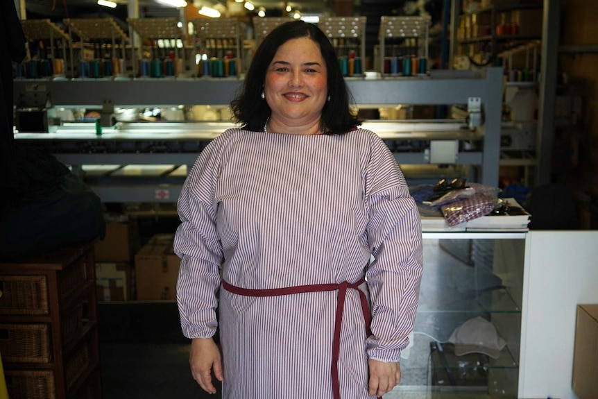 Dr Maria Boulton smiles as she wears one of the gowns for health workers made at the Brisbane factory.