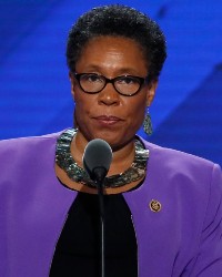 Marcia Fudge at a 2016-marked podium with a gavel and microphone.
