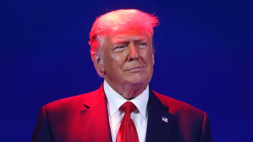 Former U.S. President Donald Trump under a spotlight at the 2021 CPAC conference