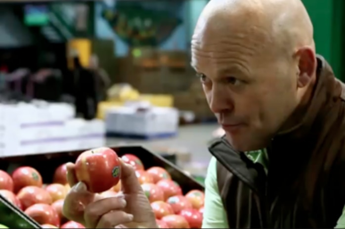 Wholesaler Shaun McInerney holds an apple in the Sydney Markets.