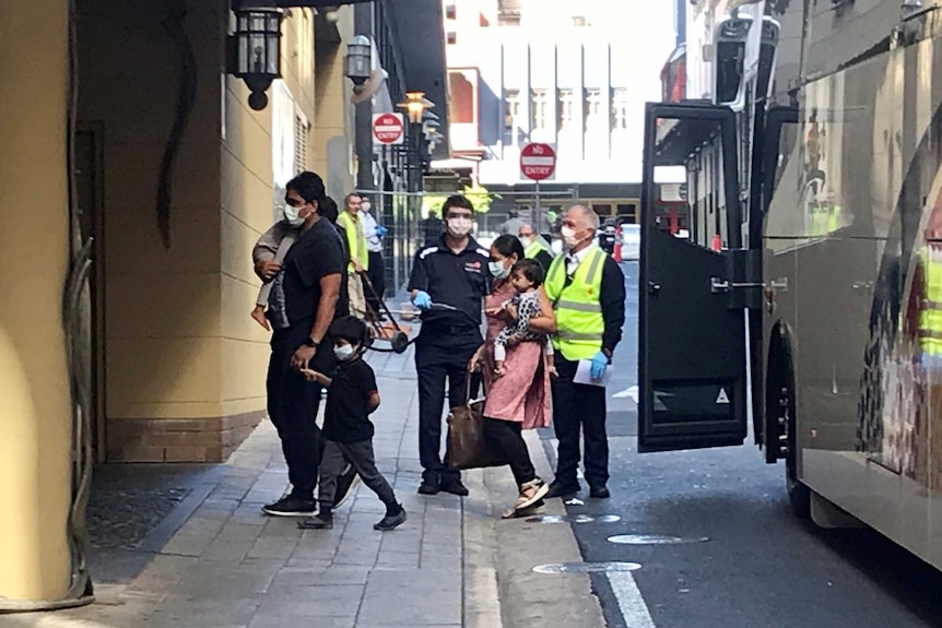 A family walks onto the footpath from a bus