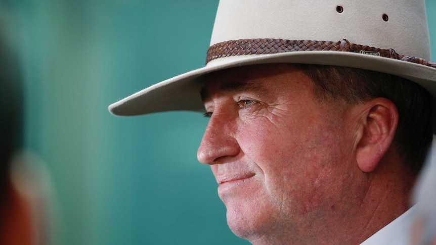 Mr Joyce wears an Akubra hat, looking to the side of frame.