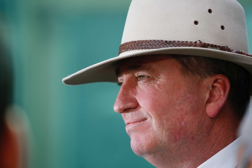 Mr Joyce wears an Akubra hat, looking to the side of frame.