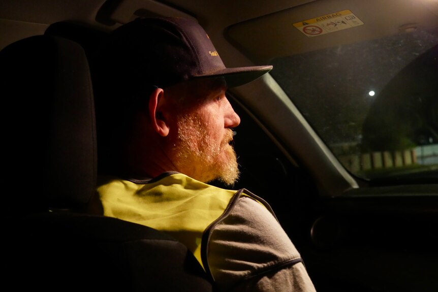 Man sitting in a car wearing a hat
