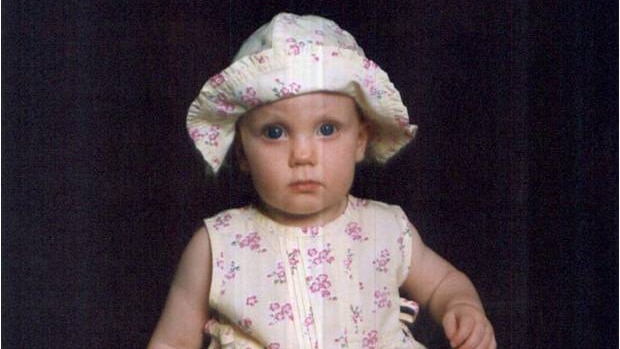 A portrait of baby Leonie Astra Hutchinson in a floral dress and hat.