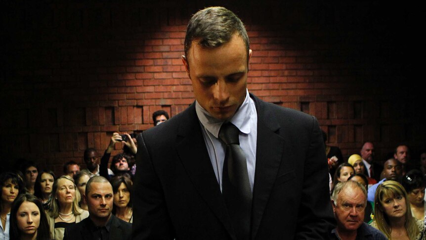 Oscar Pistorius stands in the dock ahead of court proceedings at the Pretoria Magistrates Court.