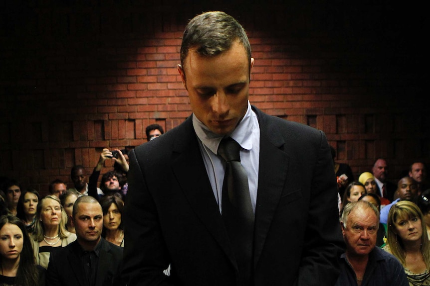 Oscar Pistorius stands in the dock ahead of court proceedings at the Pretoria Magistrates Court.