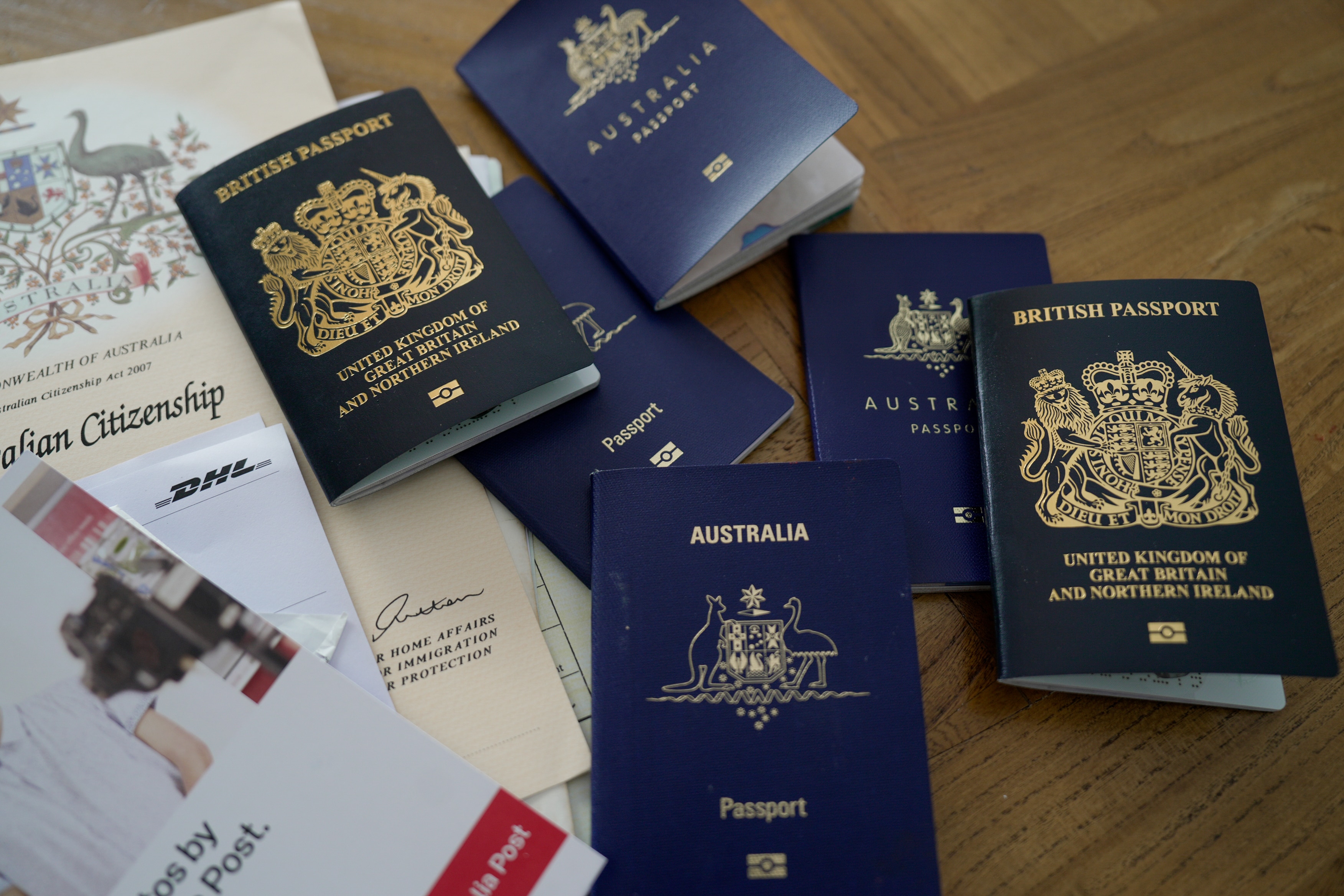 A pile of British and Australian passports on a table.