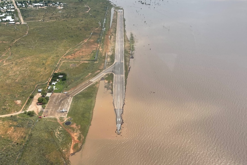 A runway half submerged under water, debris off to the sides