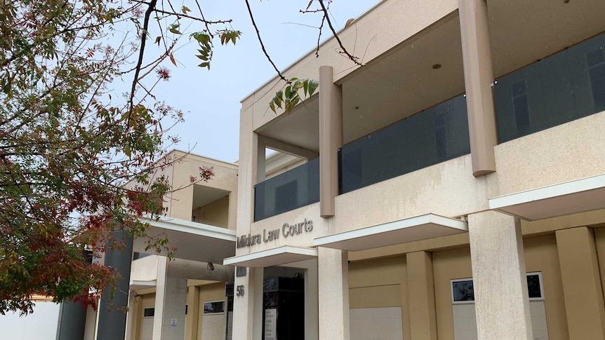 A sandy coloured, two-storey court building.