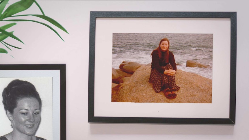 old photos hang in photo frames on a wall. Both photo frames have young women in them.