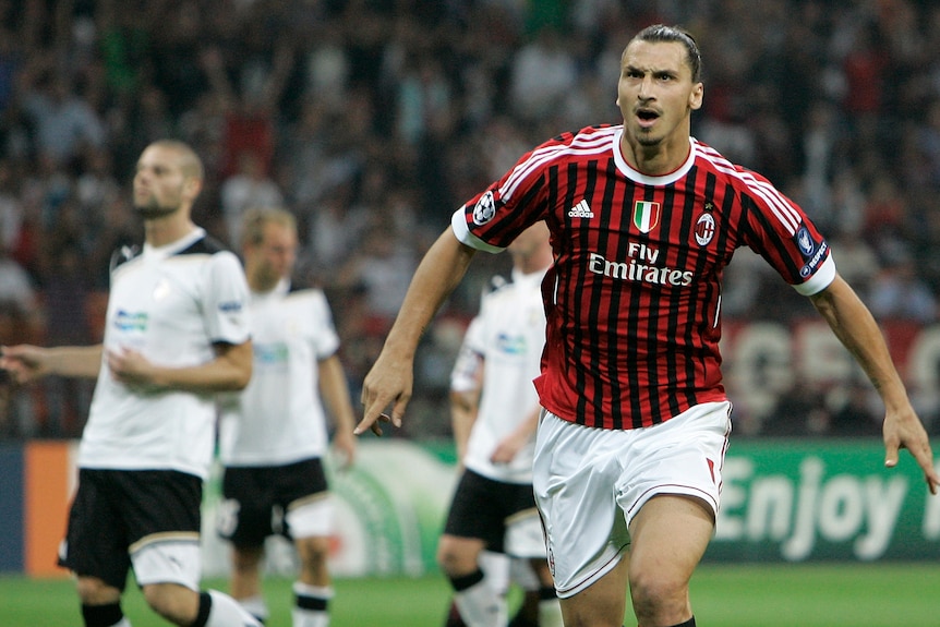 Footballer Zlatan Ibrahimovic runs with arms outstretched and fingers pointing as he celebrates a goal for AC Milan.