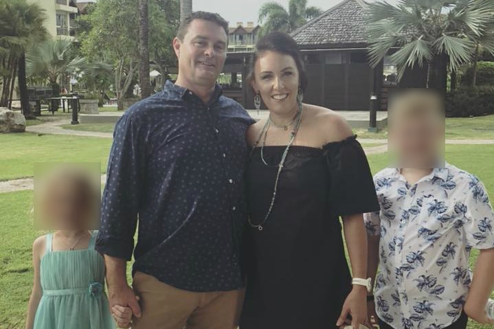 Image of a couple with their children in a tropical location