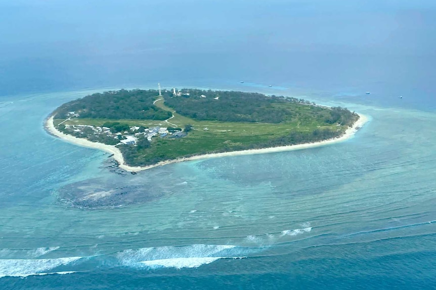 A coral island in blue water.