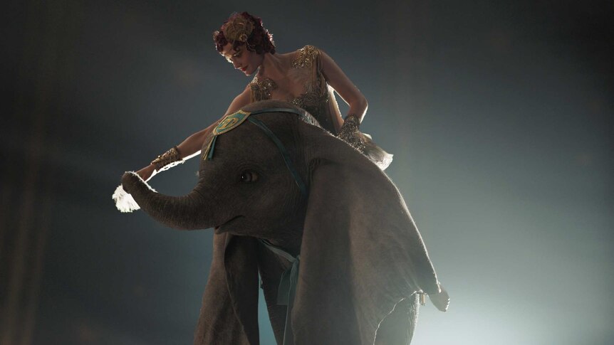 A still from the 2019 film Dumbo featuring actor Eva Green as Collette Marchant with the CGI Dumbo.