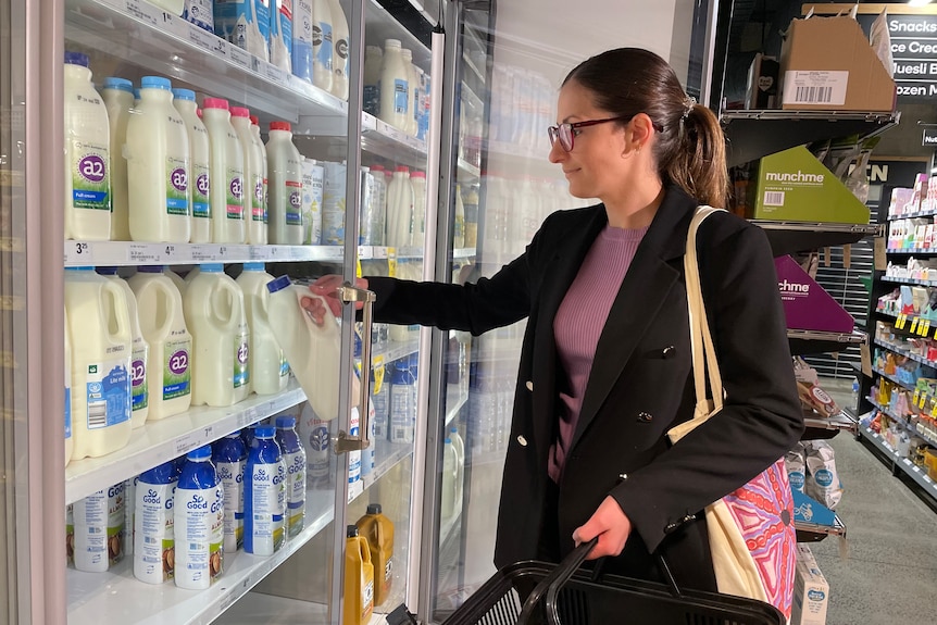 Christina Zorbas grabs a carton of milk out of the fridge at the supermarket.