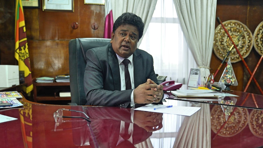 A Sri Lankan man sitting at a very big desk