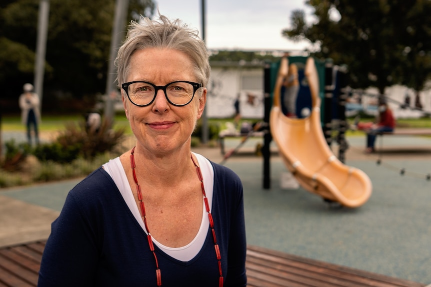 Helen smiling at the camera, with a playground visible in the background.