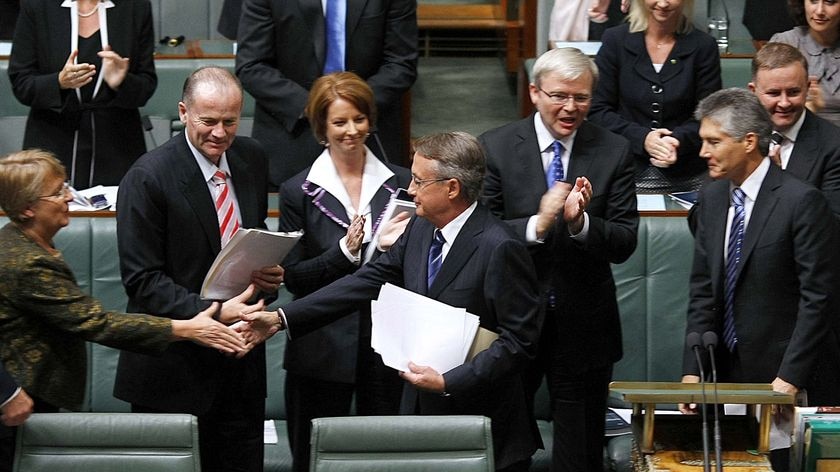 The Labor front bench, including Prime Minister Kevin Rudd, applaud Treasurer Wayne Swan