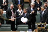The Labor front bench, including Prime Minister Kevin Rudd, applaud Treasurer Wayne Swan