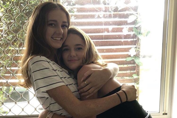 Two teenage girls hugging
