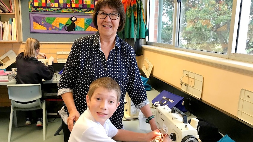 Pheonix Jones, a Year 7 boy is learning how to sew from his teacher Kaye Bailey.