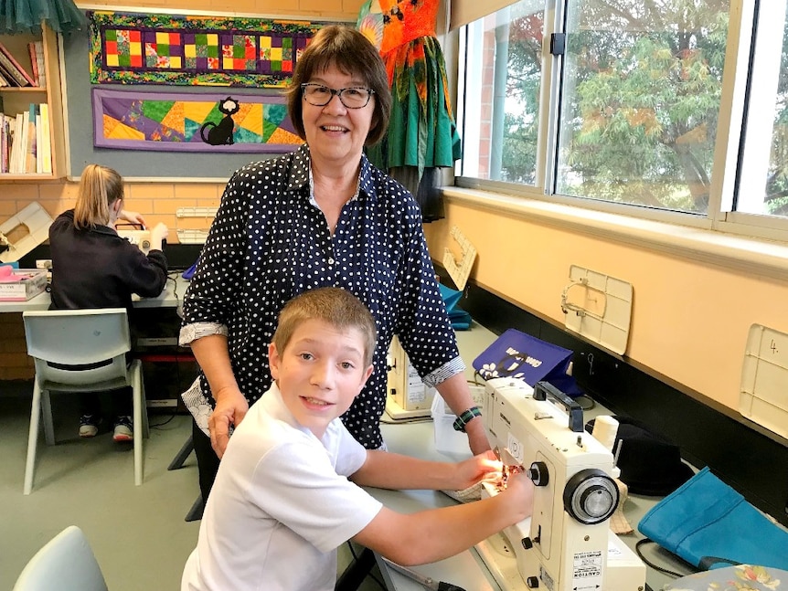 Pheonix Jones, a Year 7 boy is learning how to sew from his teacher Kaye Bailey.