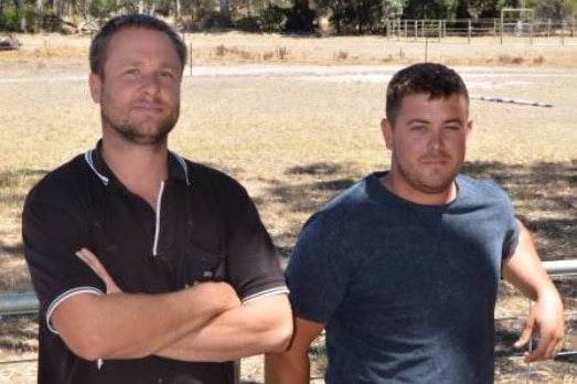 Ben McKenzie and Lee Dobson lean against a gate on a rural property