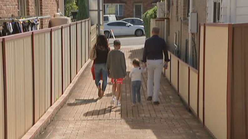 A family walking down a driveway.