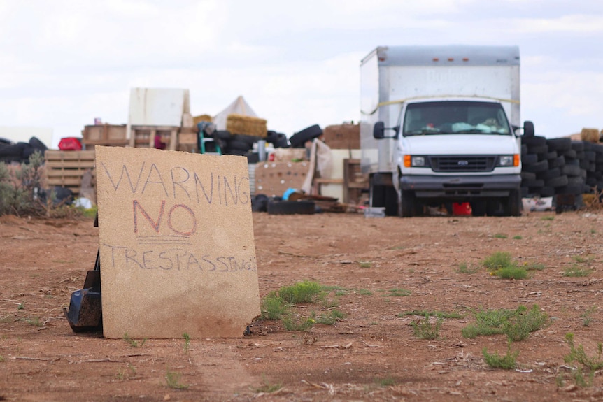 Photo shows a "no trespassing" sign outside the location where people camped.