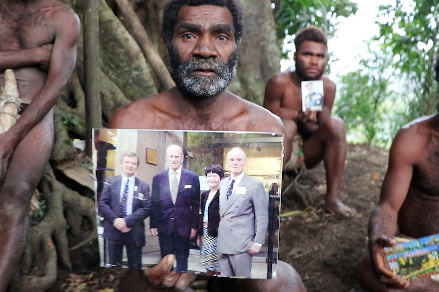 Three Ni-Vanuatu men holding photos of Prince Philip.