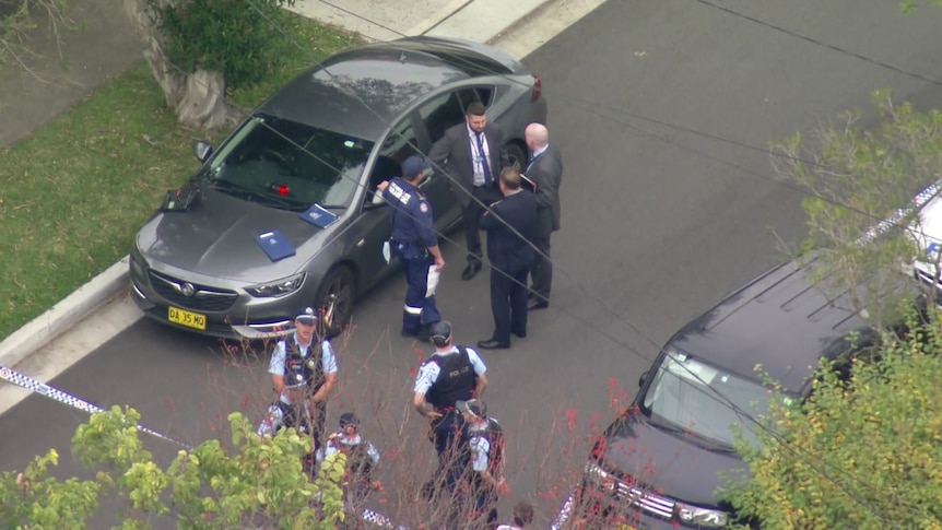 Police standing next to a car