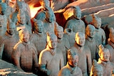 Close-up of terracotta warriors in excavation site.