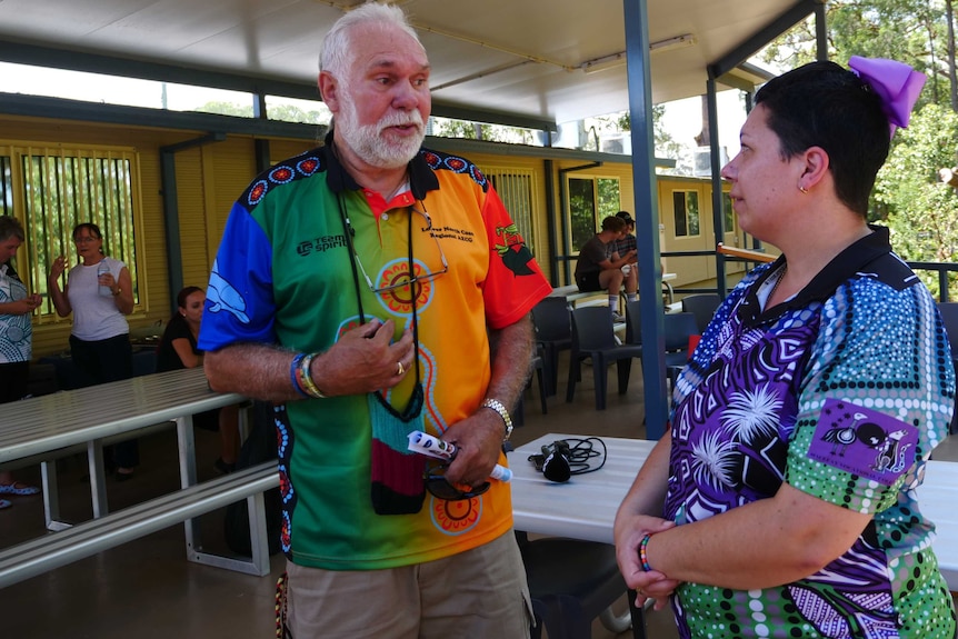 A man and a woman talking at an event outside a school