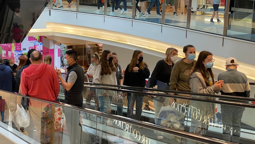 People on escalators at a busy shopping centre 