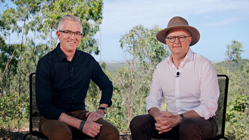 David Spears wearing a dark navy shirt sitting on a chair next to Anthony Albanese wearing a wide brimed hat