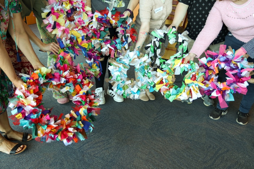 5 colourful paper garlands held in a circle