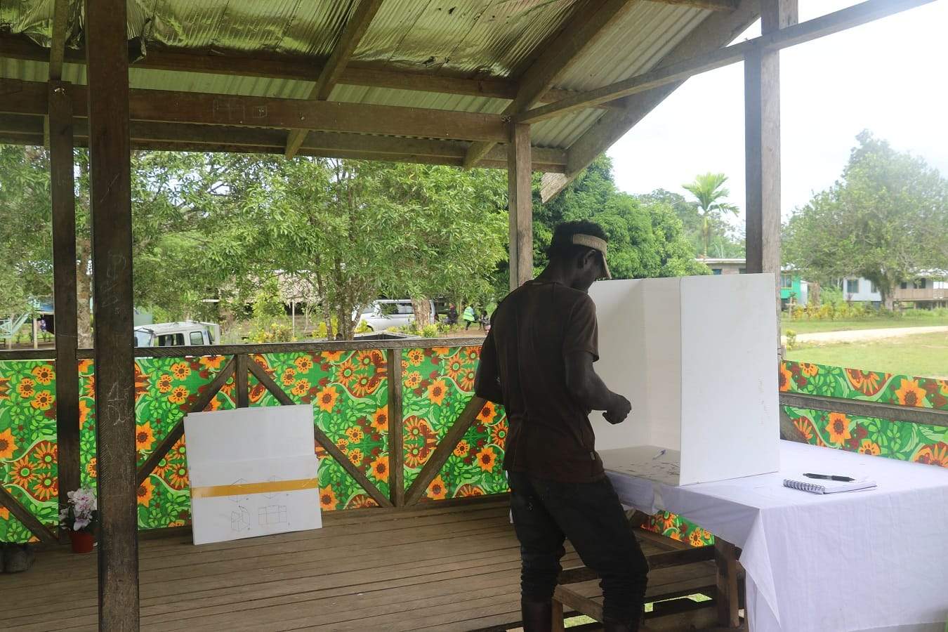 A man votes in a booth on a verandah in Bougainville