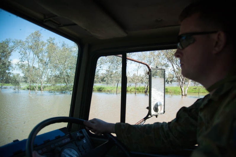An army officer drives through floodwaters at Forbes, NSW.