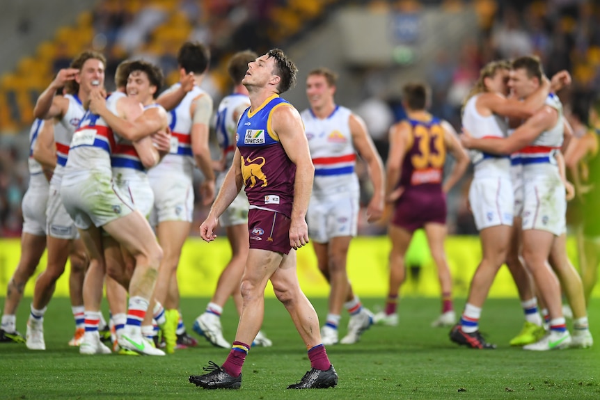 Lincoln McCarthy looks skywards in frustration as Bulldogs players celebrate behind him