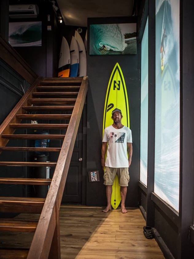 Dylan Longbottom stands with one of his surfboards.