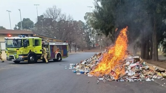 A fire engine arrives to put out a mound of rubbish that caught fire.